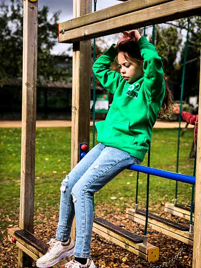 Young Girl Looking Pensive On Outdoor Play Equipment