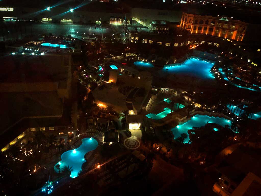 view of several pools at night time from mandalay bay hotel