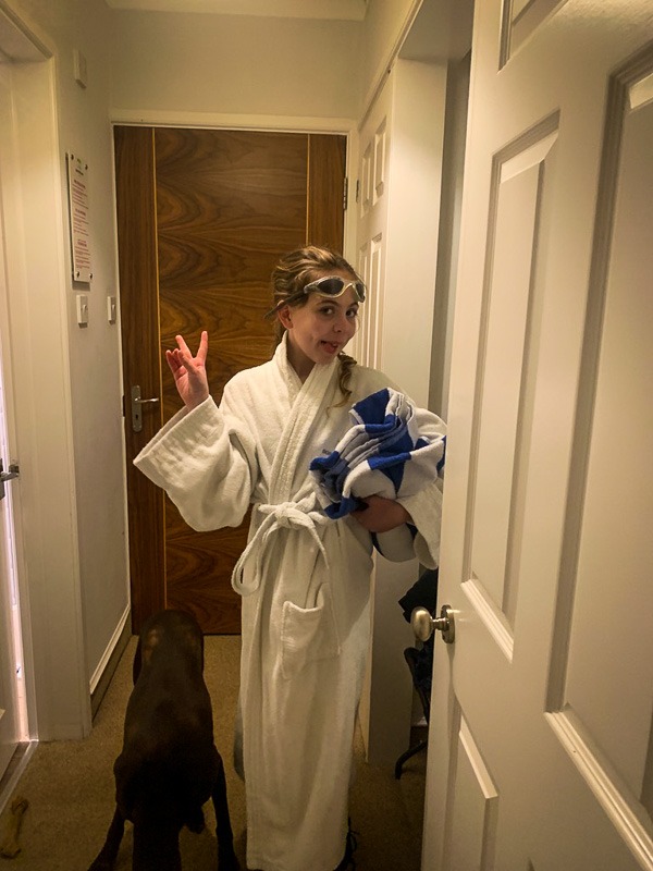 piper quinn with hair tied back wearing a white dressing gown with goggles on her head