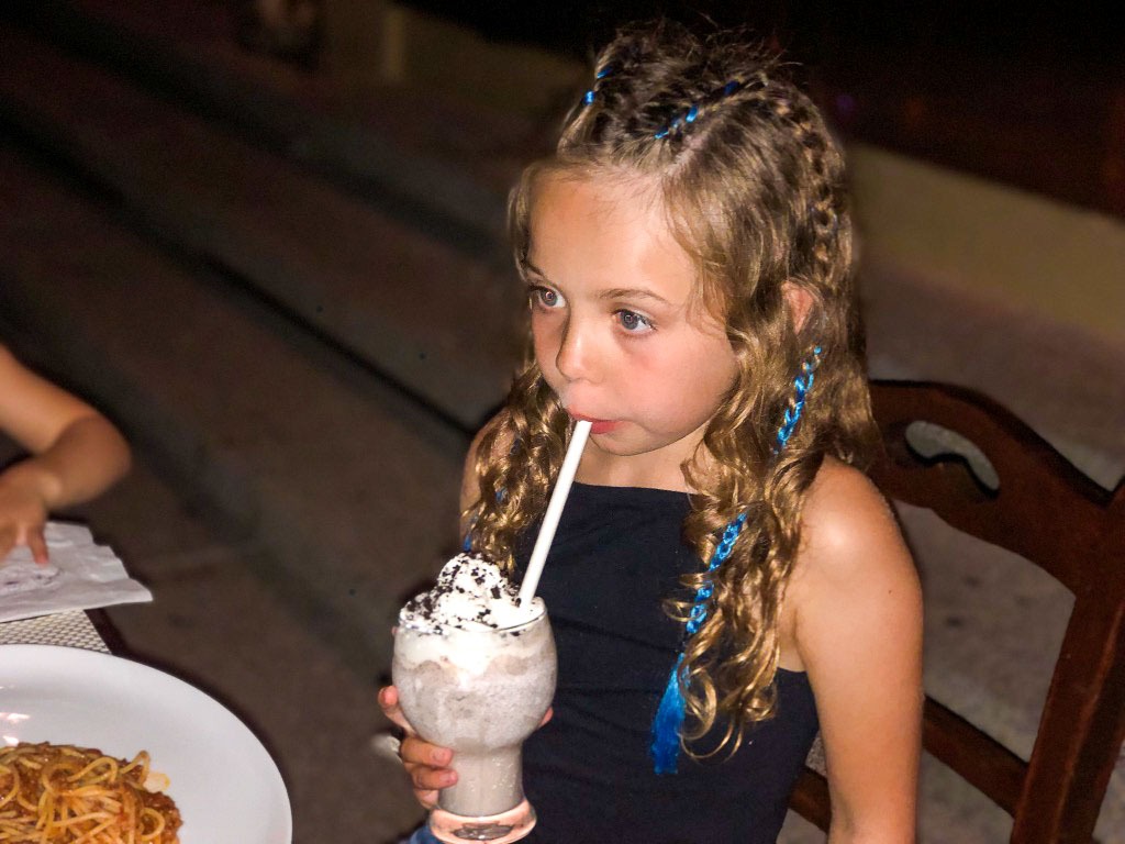 piper quinn with braided hair drinking a thick chocolate milkshake with cream on the top through a straw