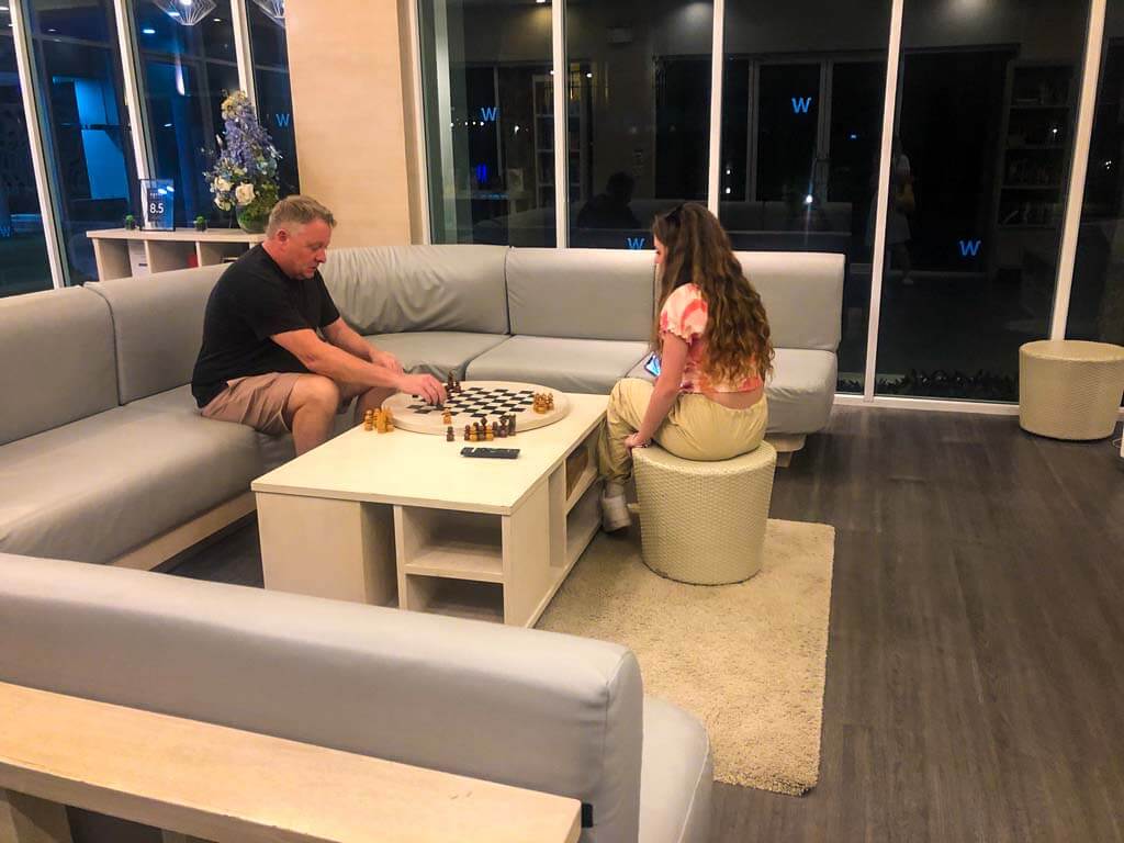 piper and nigel quinn playing chess in a hotel lobby