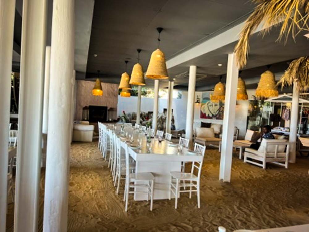 white table on sandy floor at plettenberg beach
